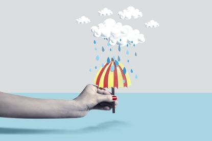 Illustration of a hand holding an umbrella to block rain.